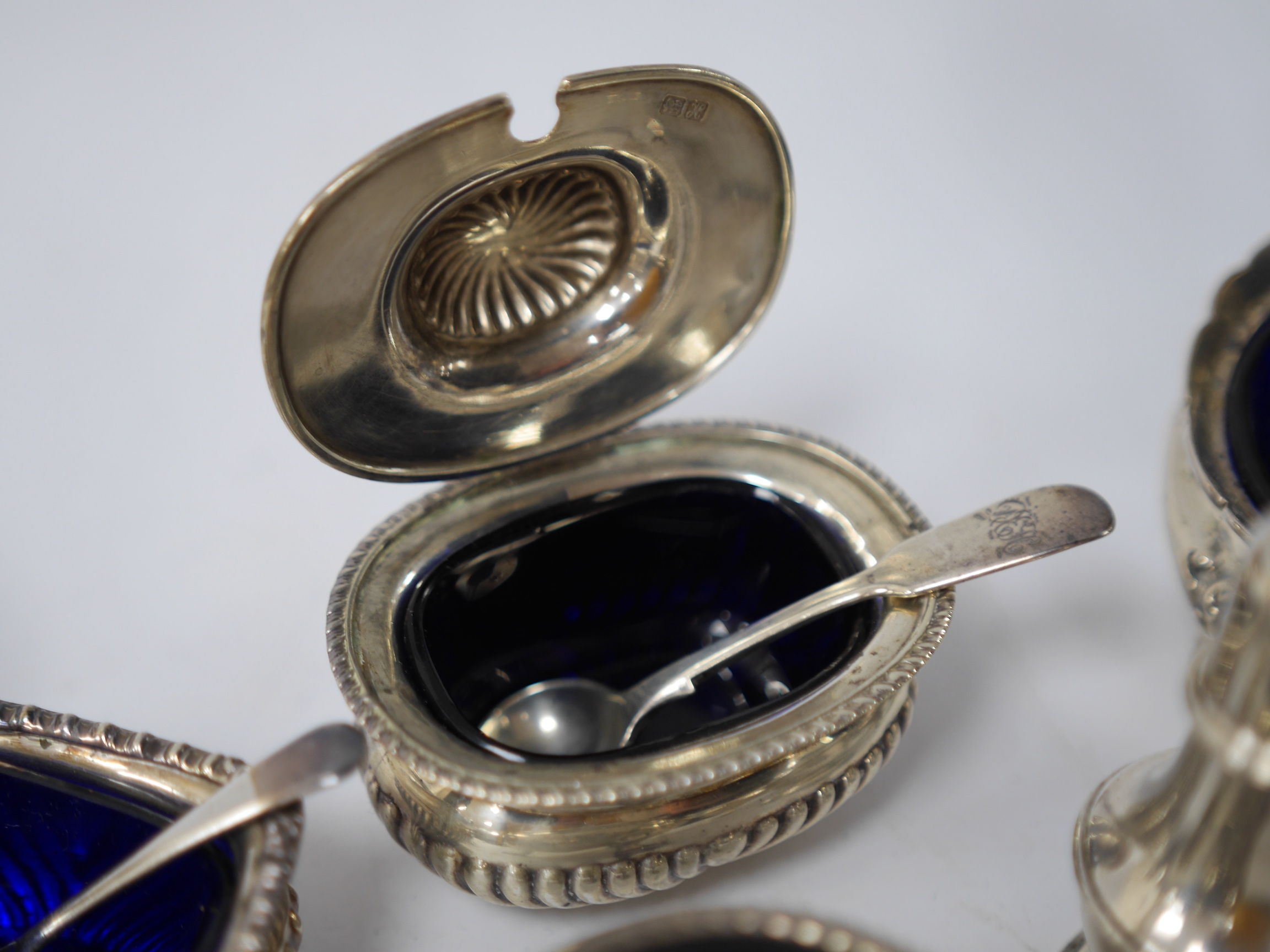 A pair of late George III silver circular salts, London, 1817, together with six later assorted silver condiments. Condition - poor to fair